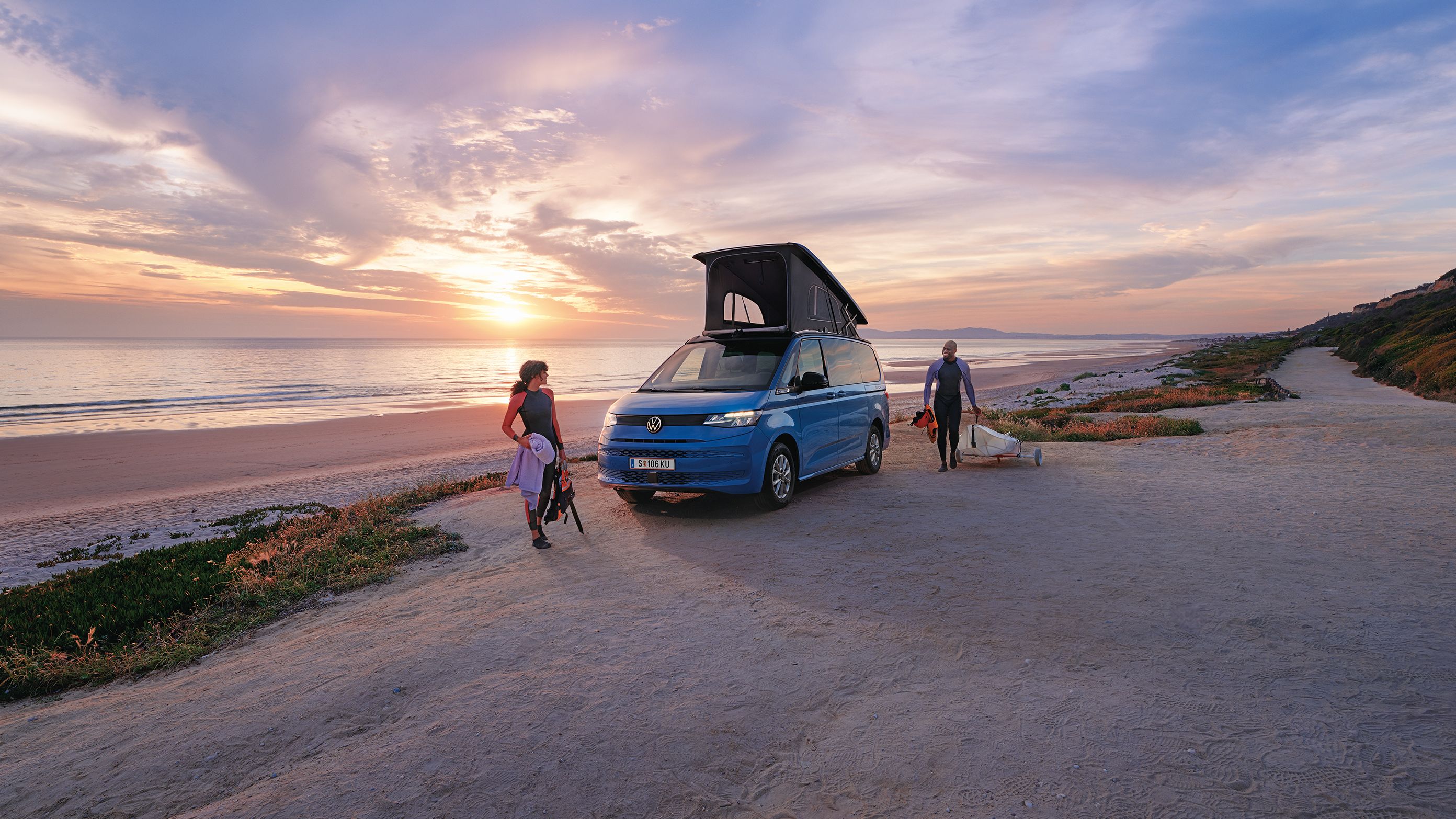 Neue California steht mit ausgeklapptem Dach an einem Strand bei Sonnenuntergang