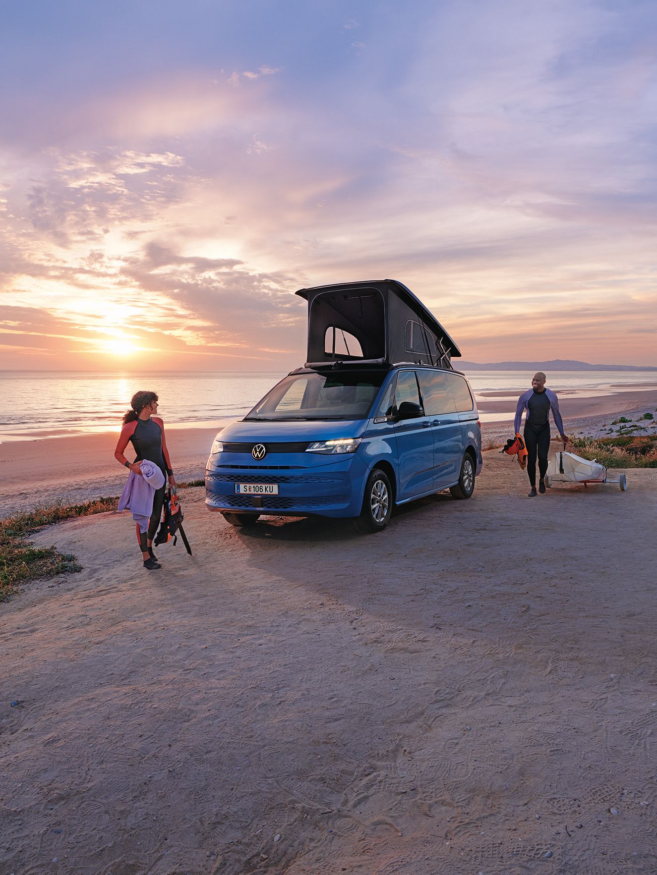 Neue California steht mit ausgeklapptem Dach an einem Strand bei Sonnenuntergang