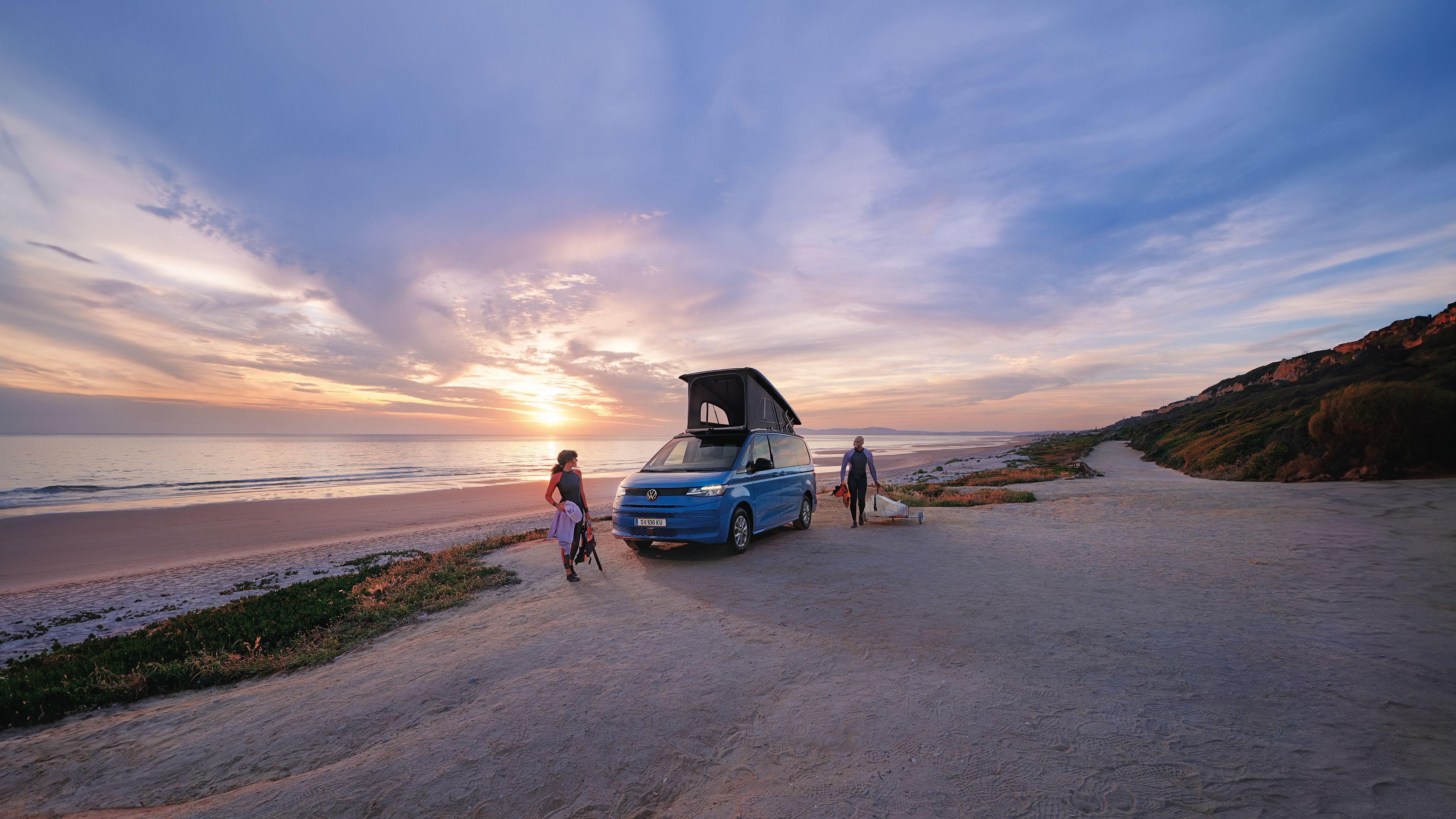 Neue California steht mit ausgeklapptem Dach an einem Strand bei Sonnenuntergang