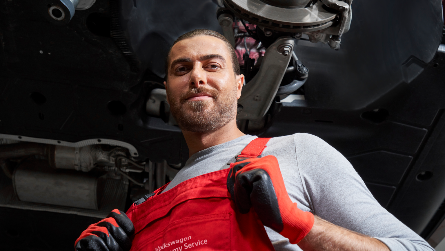 Ein VW Mechaniker bei der Arbeit an den Bremsen und Bremsscheiben