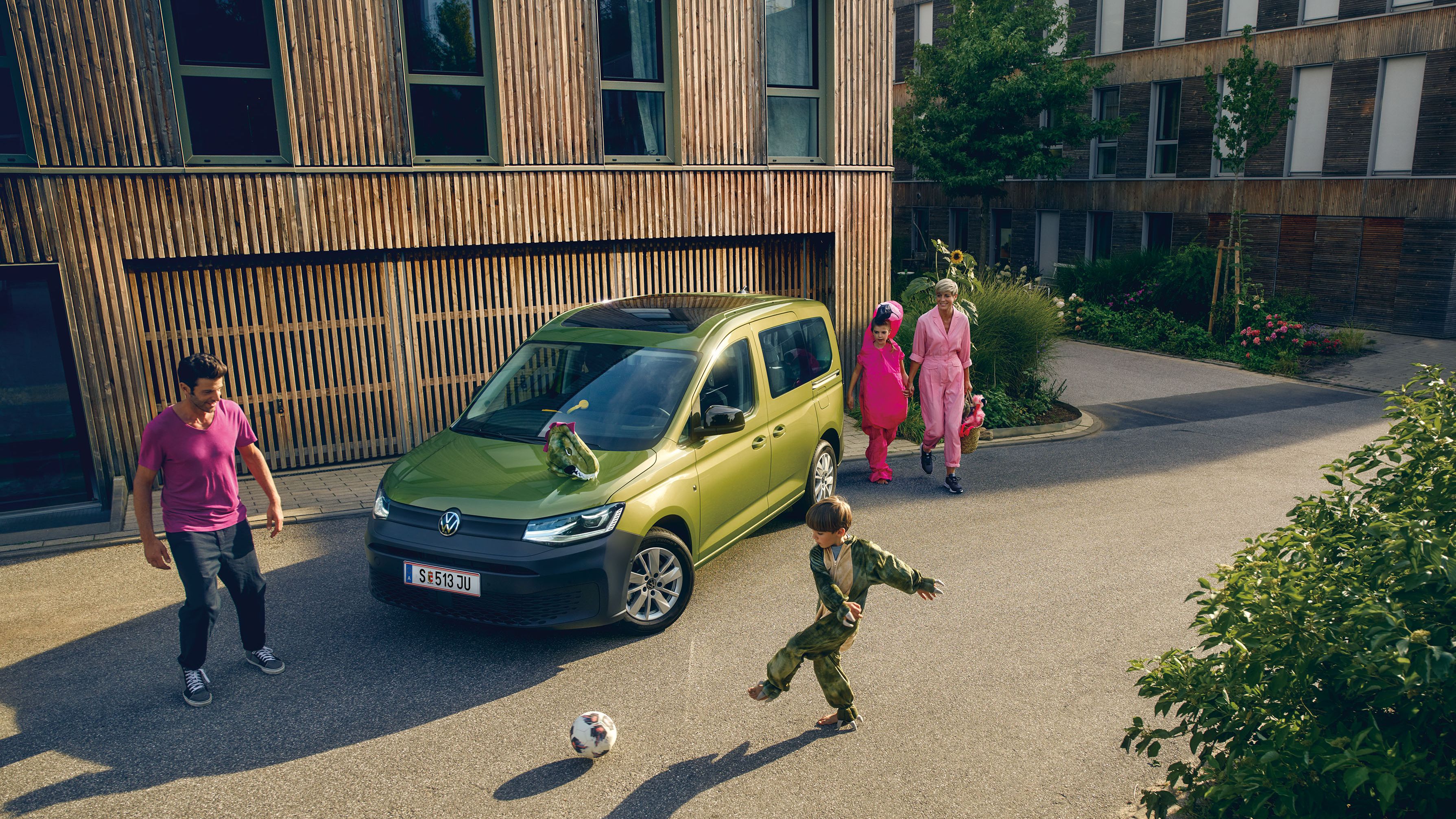 Kinder spielen vor einem Volkswagen Caddy