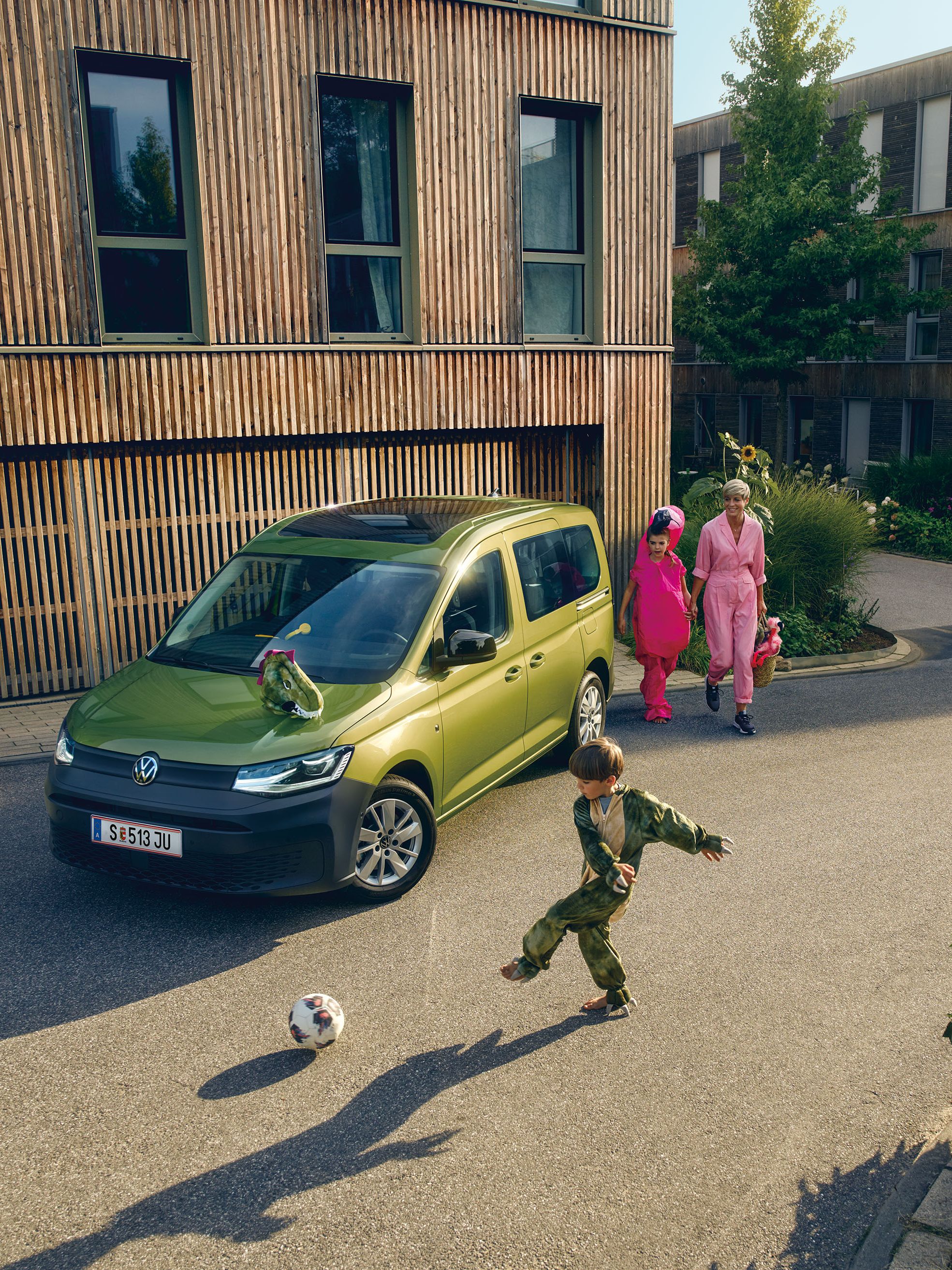 Kinder spielen vor einem Volkswagen Caddy