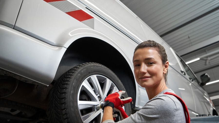 Eine Volkswagen Technikerin beim Reifenwechsel