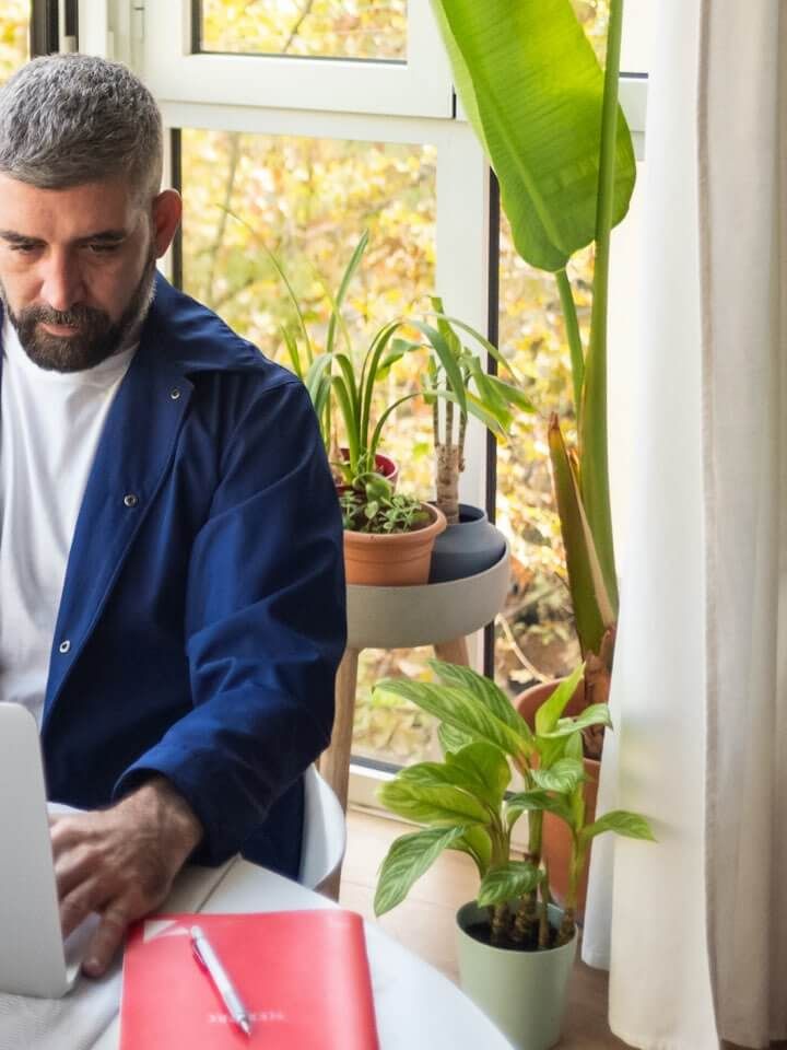 Mann arbeitet am Laptop drinnen