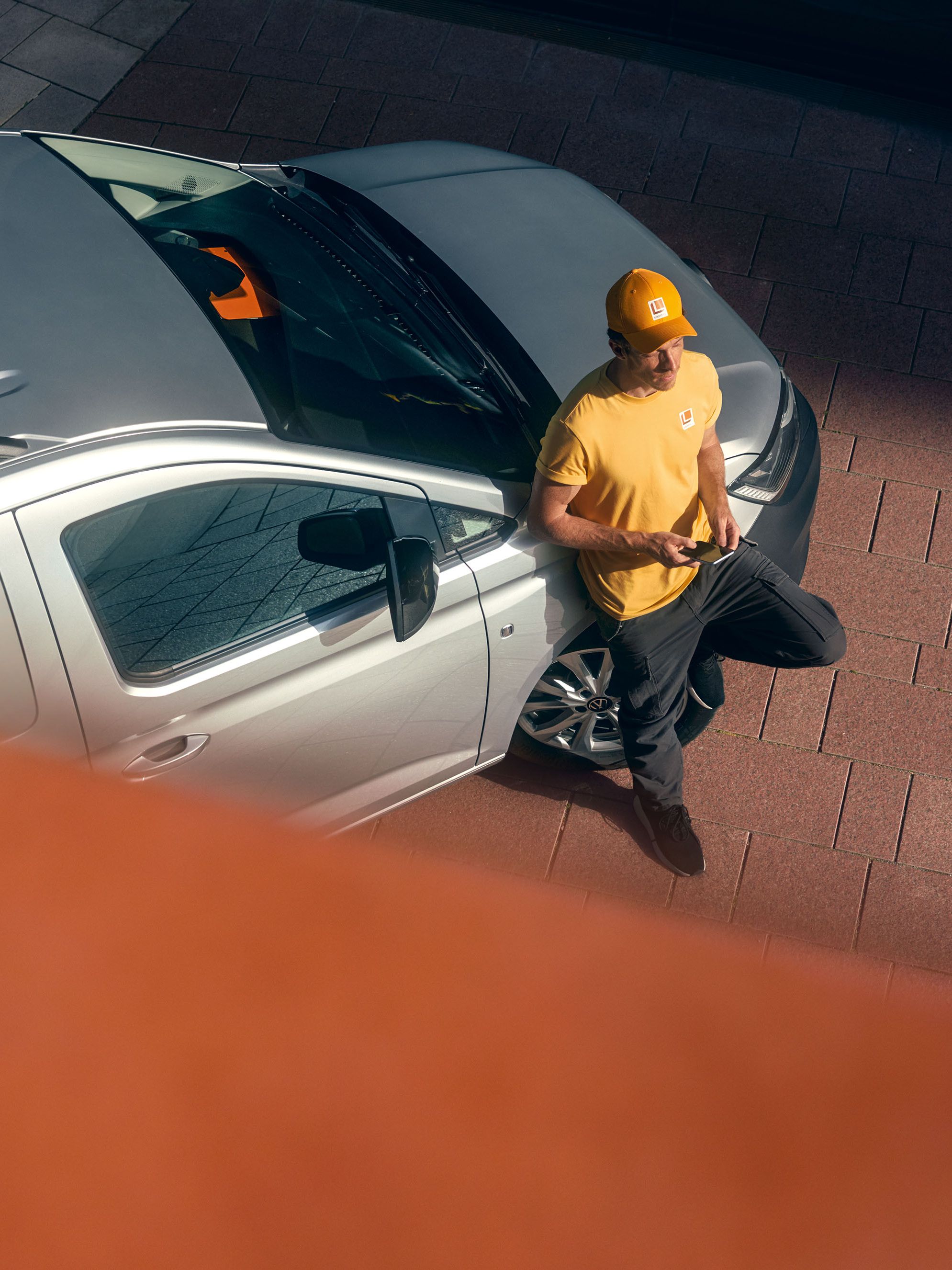 Mann lehnt an einem silbernen Caddy Cargo Maxi.