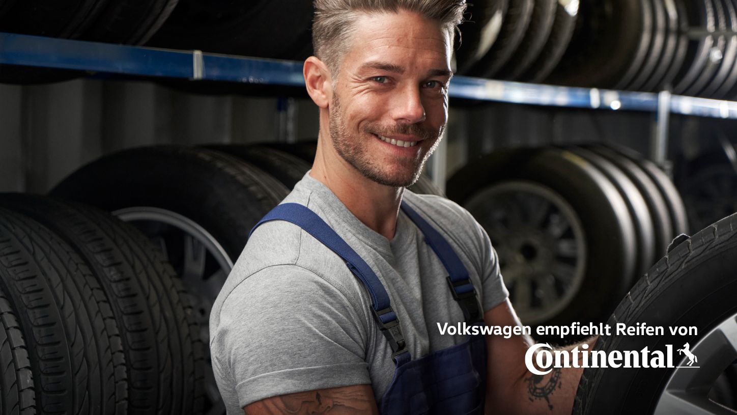 Ein Volkswagen Service Techniker schlichtet Winterkompletträder in ein Regal