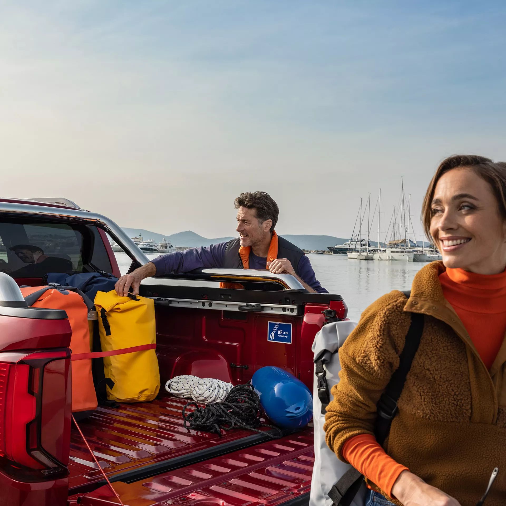 Ladefläche eines VW Amarok beladen mit Gepäck, parkt an einem Hafen