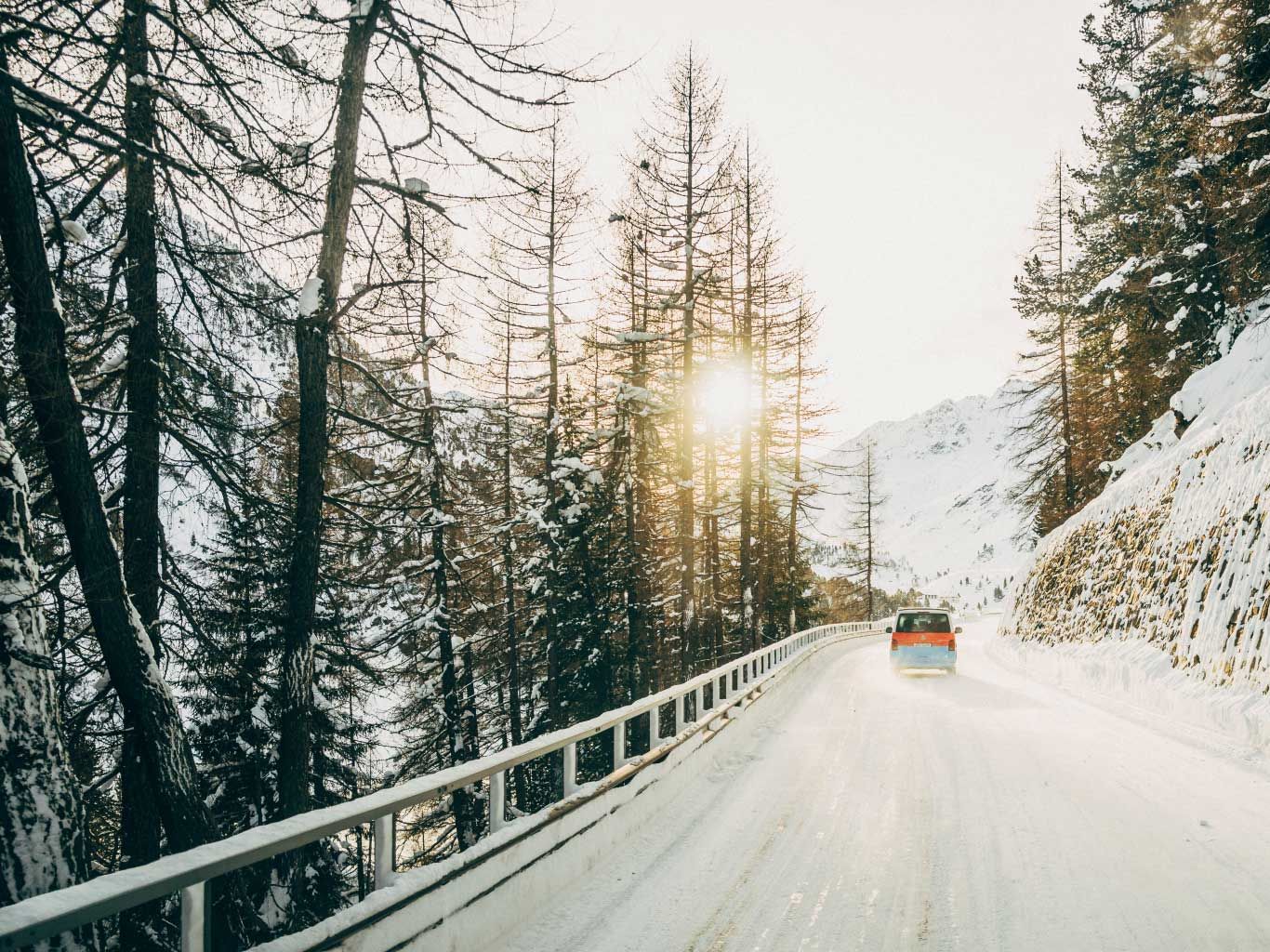 Ein VW Nutzfahrzeug fährt auf einer verschneiten Straße