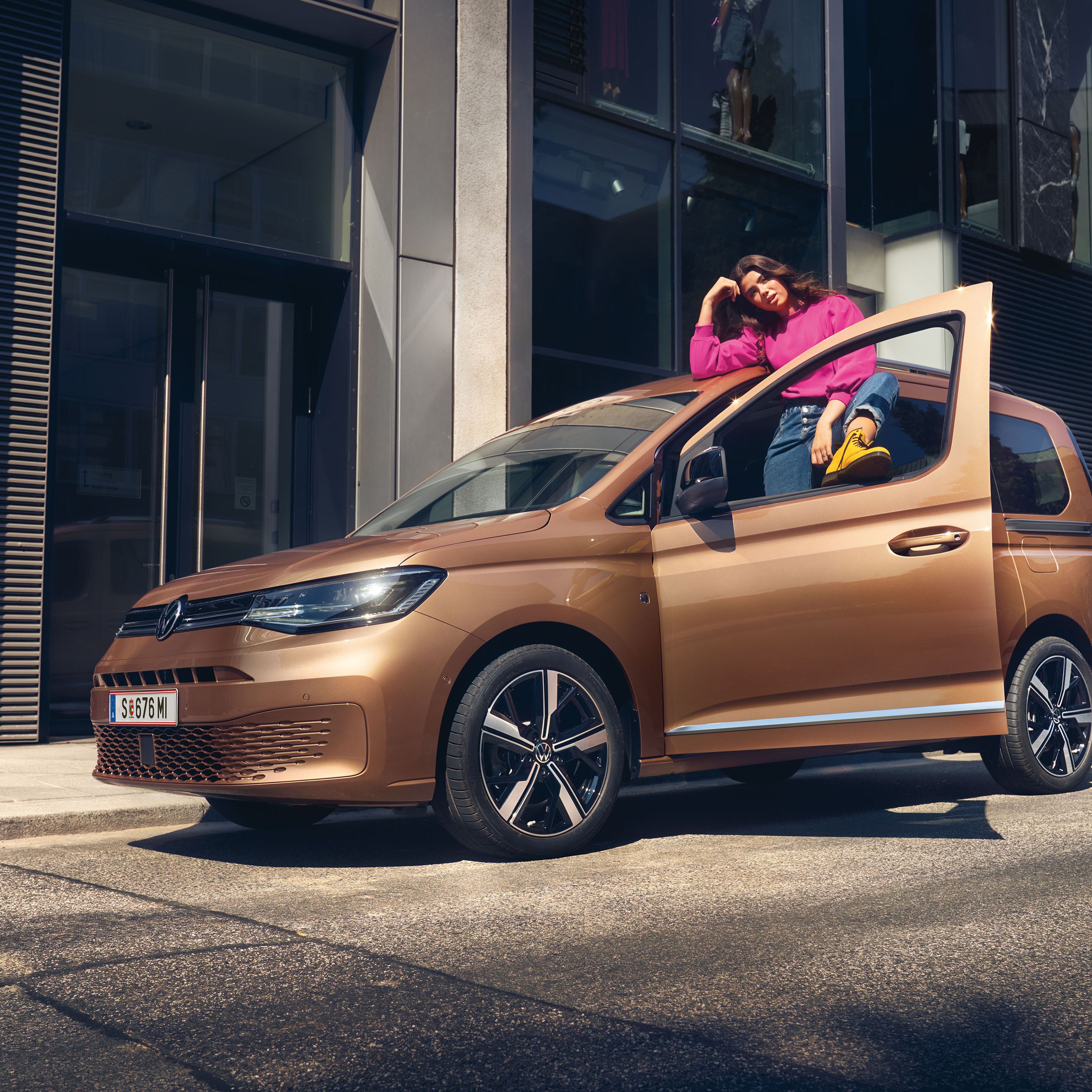 Ein VW Caddy in Copper Bronze steht auf Straße