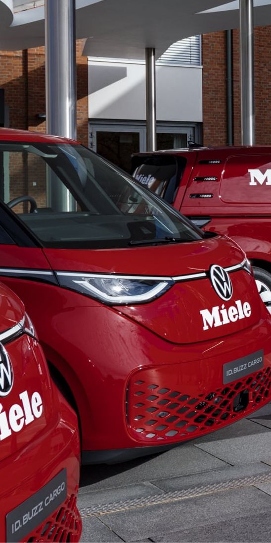 VW ID. Buzz Flotte von Miele in rot vor Miele Gebäude