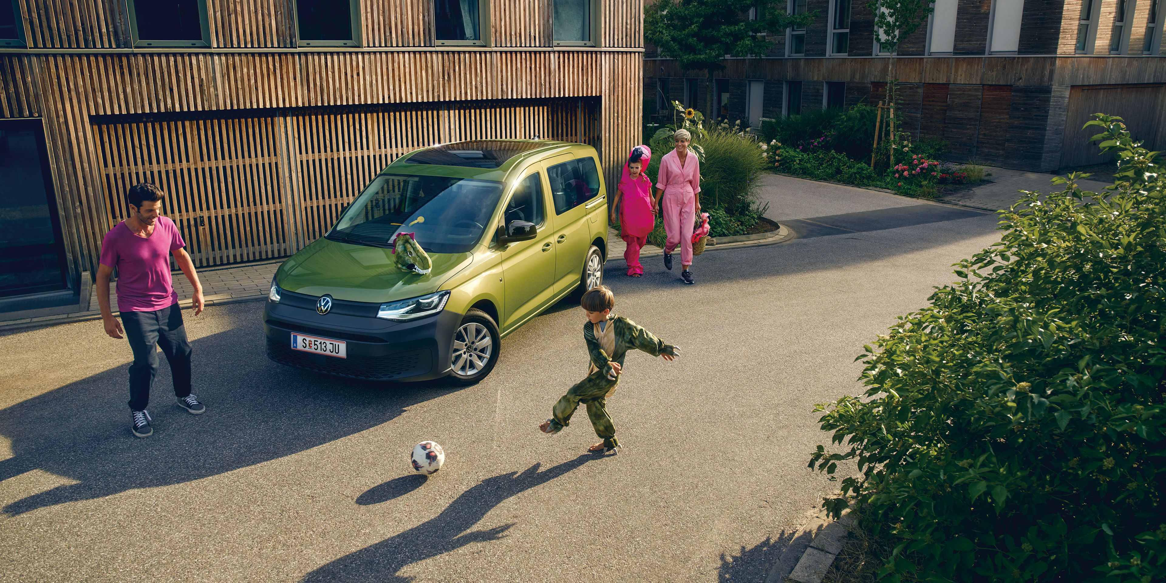 Grüner VW Caddy mit Familie