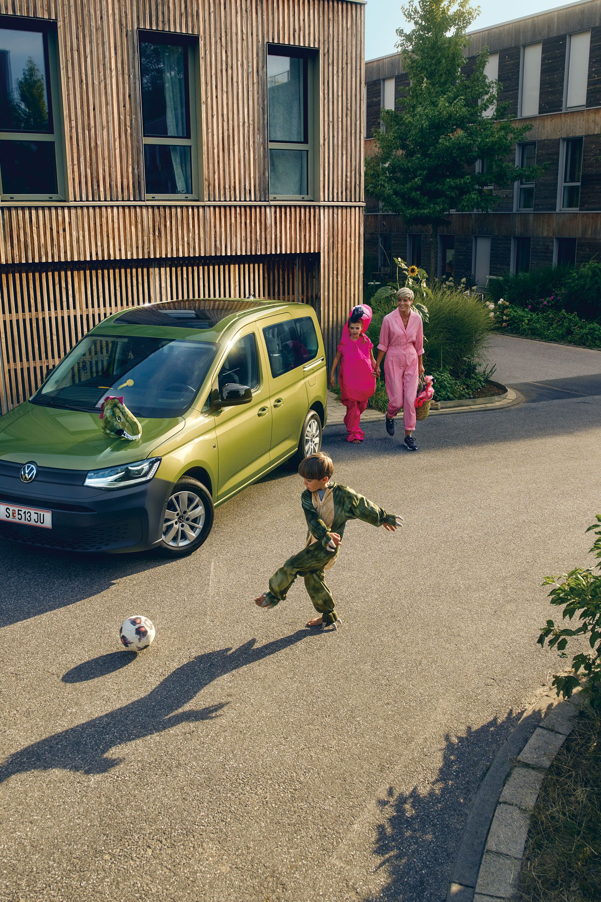 Grüner VW Caddy mit Familie