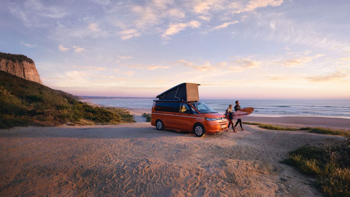 Volkswagen California mit aufgestelltem Dach, parkend am Strand