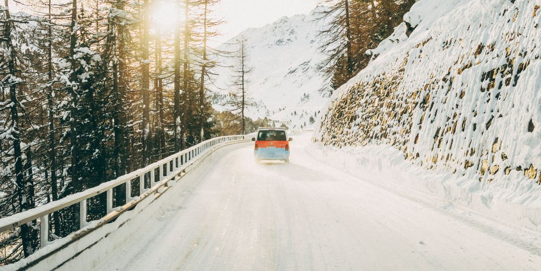 Ein Volkswagen Nutzfahrzeug fährt eine winterliche Straße entlang