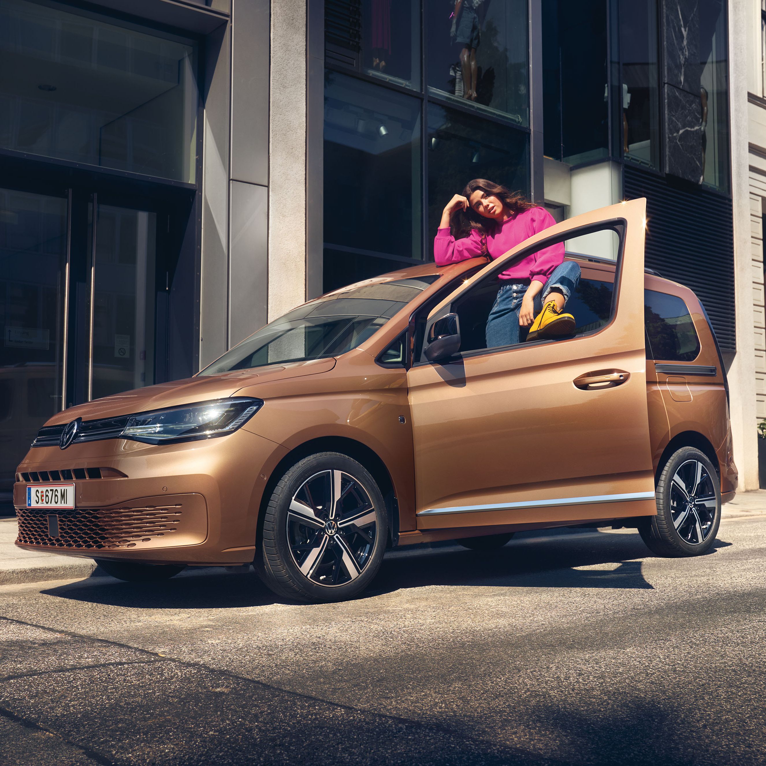 Ein VW Caddy in Copper Bronze steht auf Straße