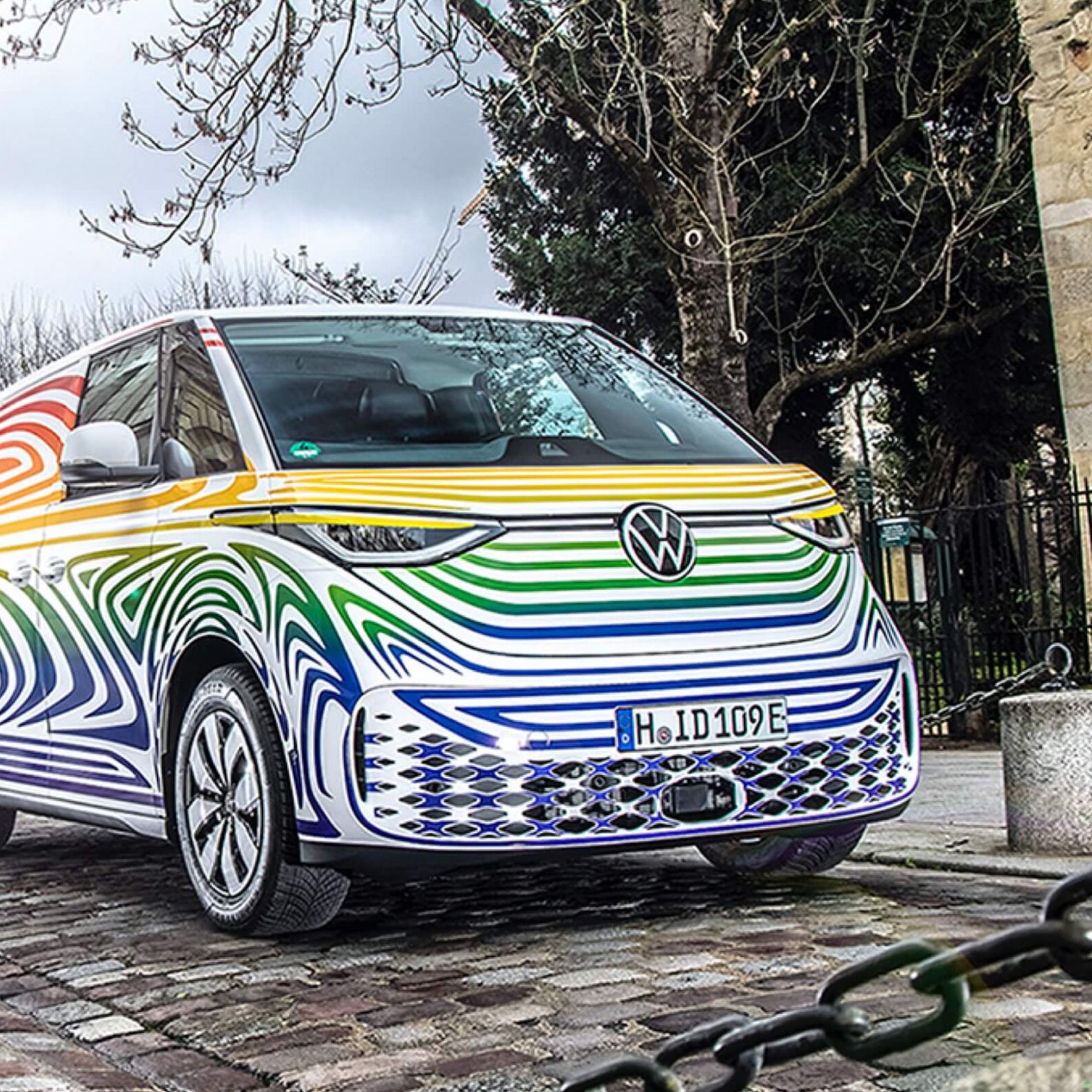 VW ID. Buzz auf Straße im bunten Camouflage