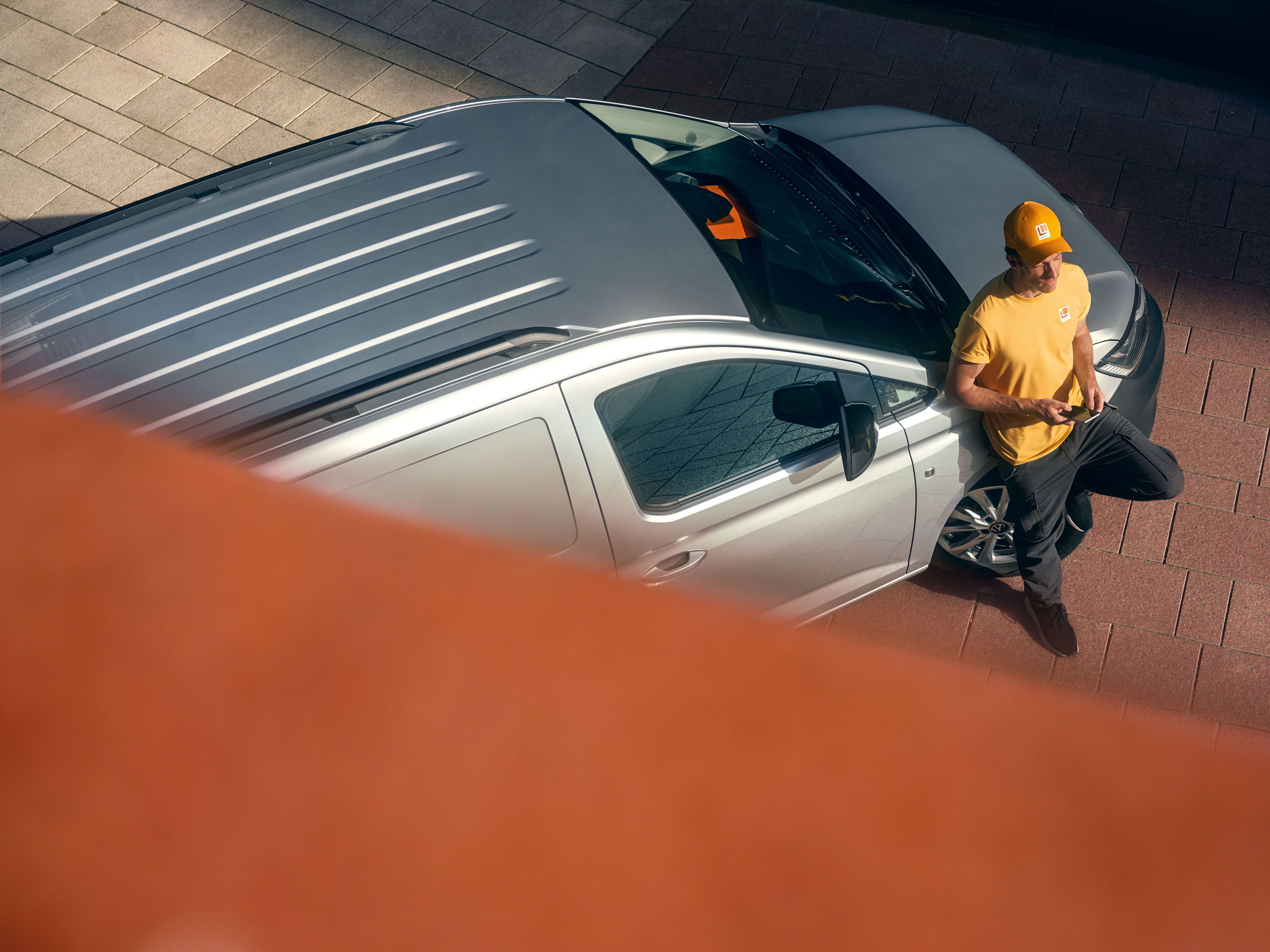 Mann lehnt an einem silbernen Caddy Cargo Maxi.